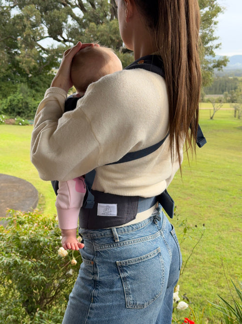 Coast | Mum carrying baby in August baby carrier outside side view showing logo