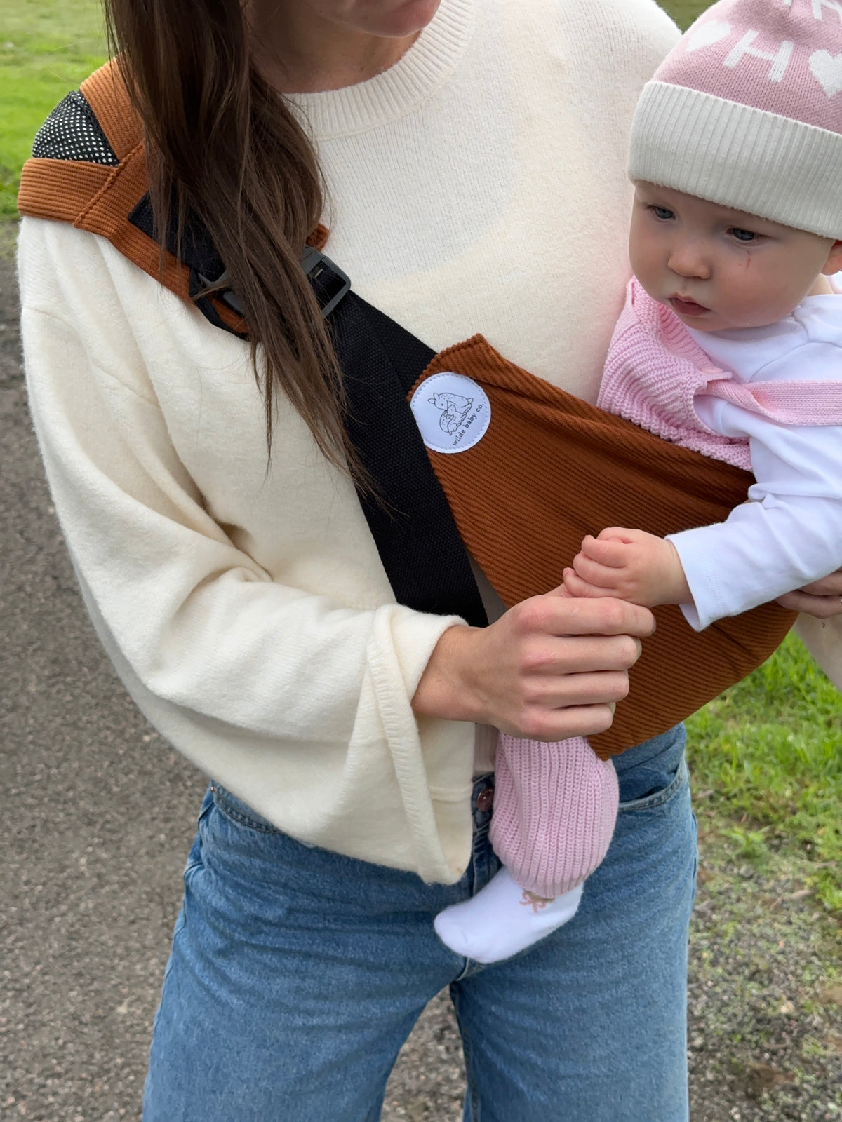 Rust | mum holding baby in ever toddler carrier closeup of logo and side view
