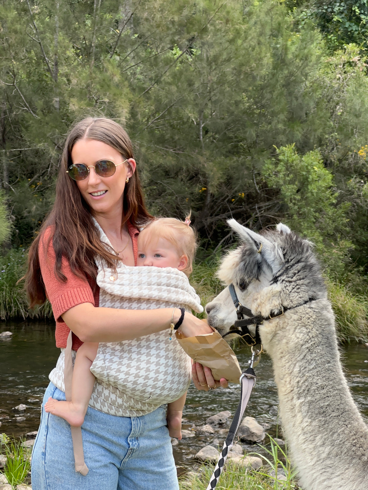 Oat | Mum carrying baby in Haven Carrier outside in nature with tree's and creek and lama